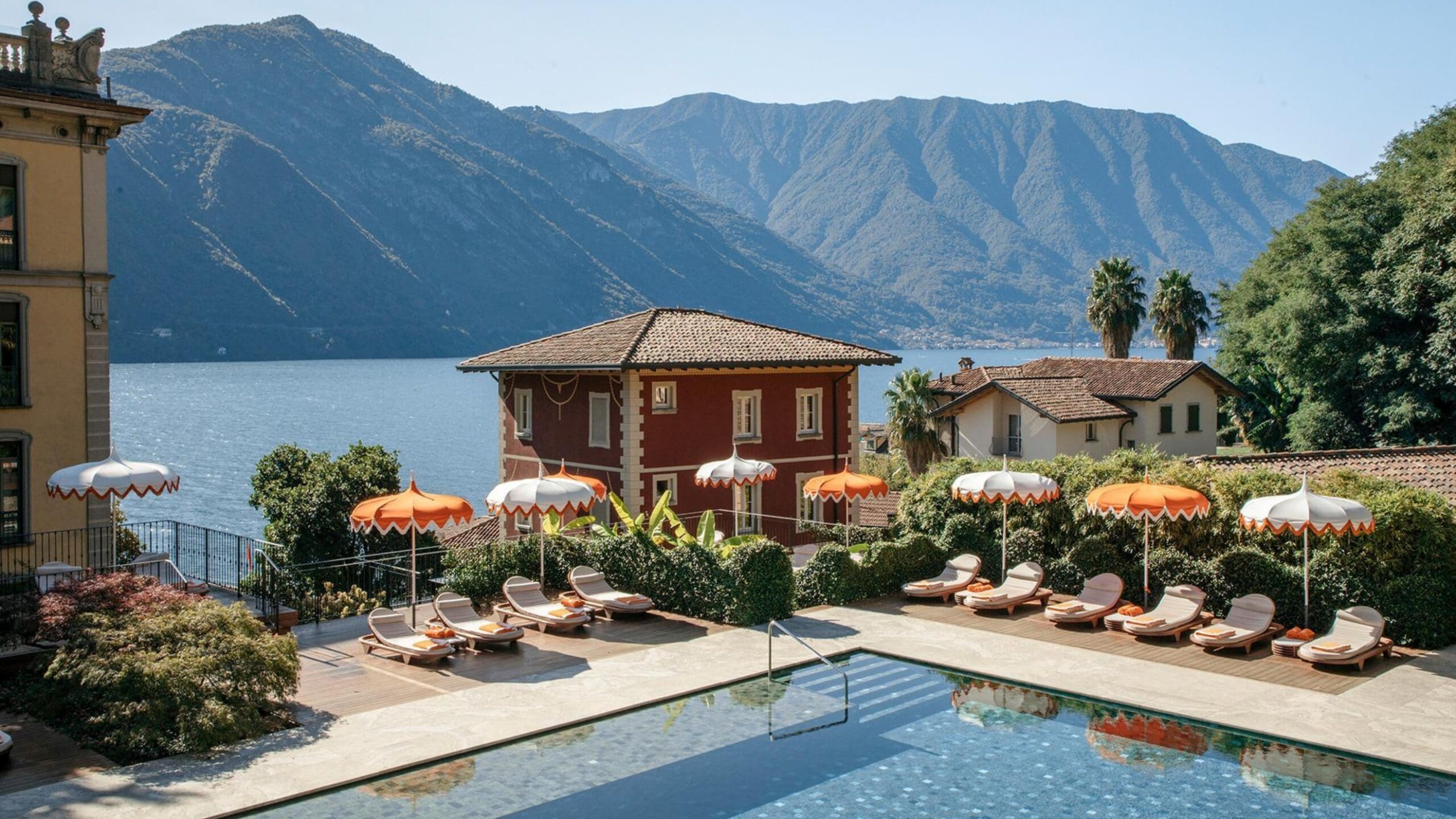 Lake Como lake holiday with boutique hotel pool, orange parasols and mountain views across the water
